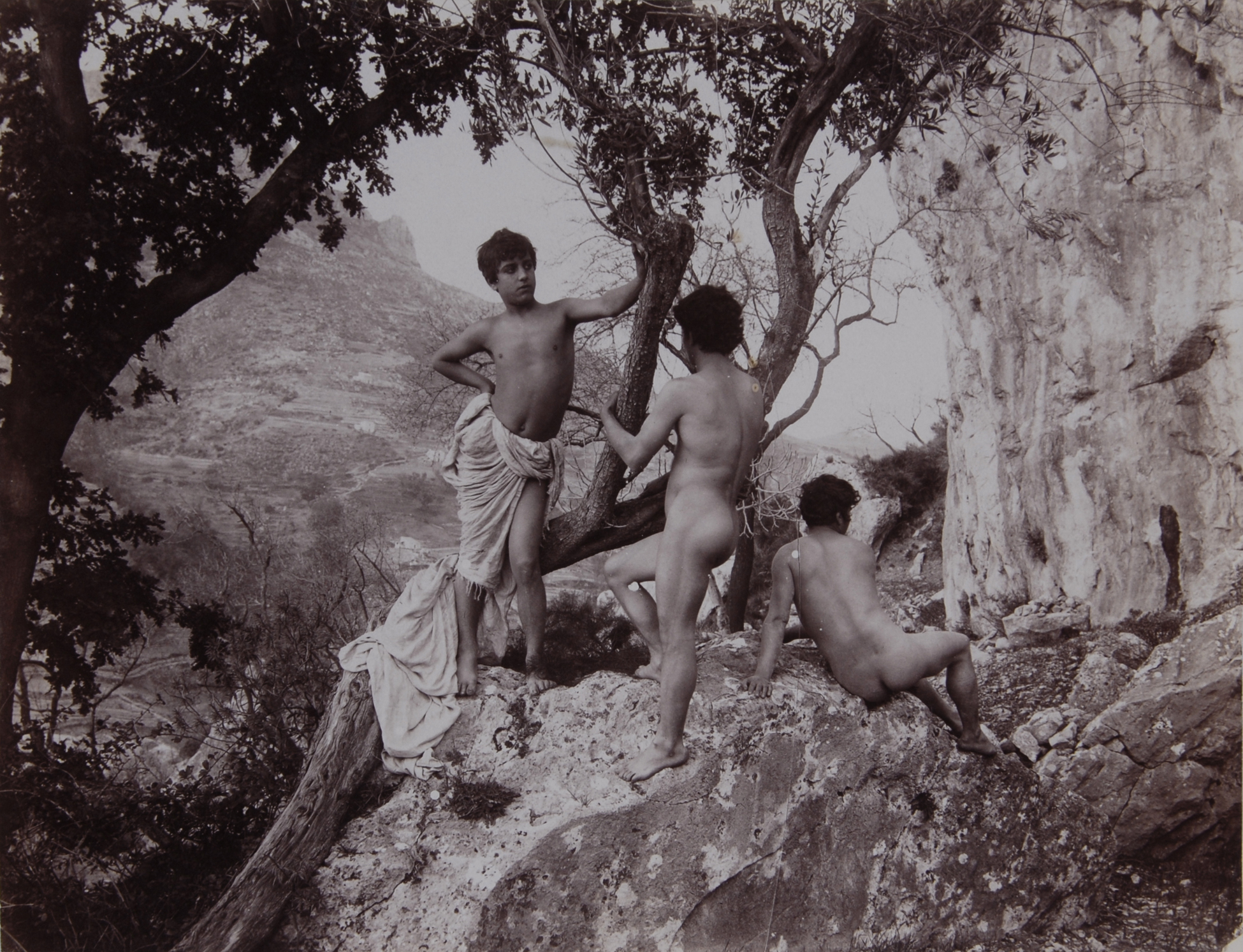 Wilhelm von Gloeden, 2 photographs: Drei sizilianische Jünglinge in der Natur; Sizilianischer Jüngling an Säule posierend